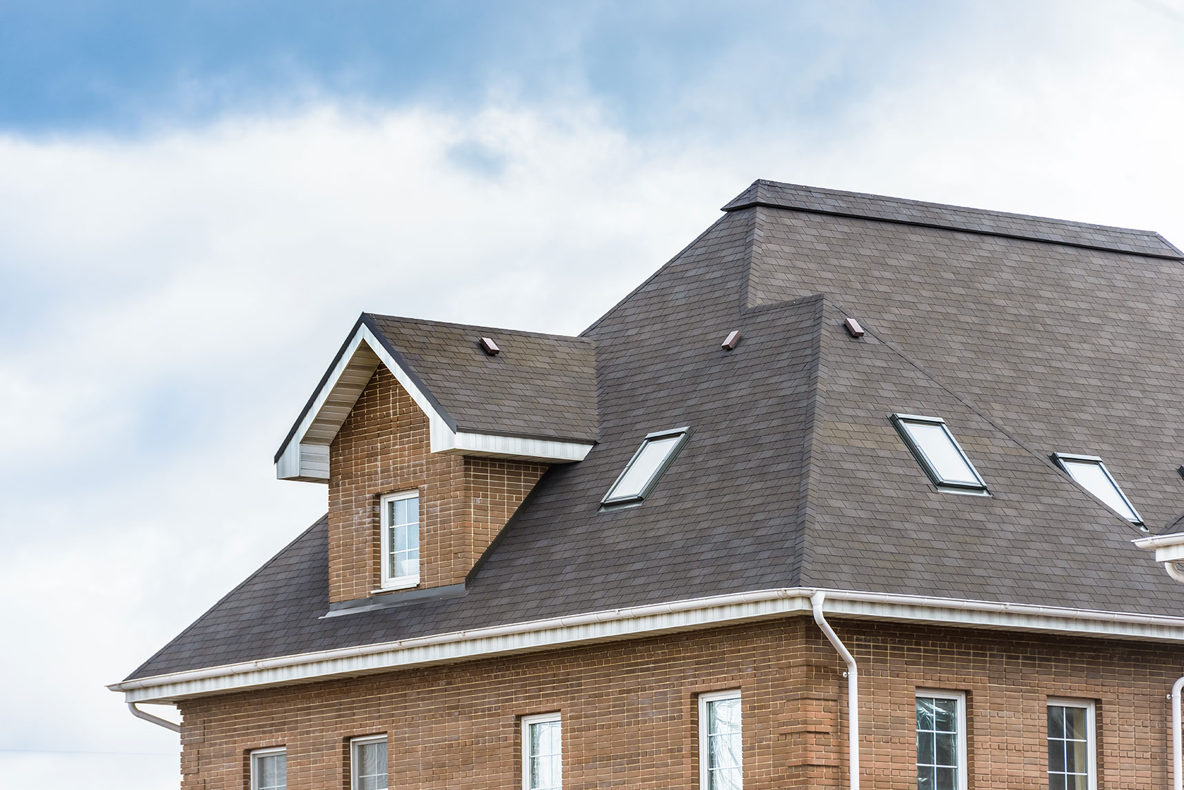 Completed roof replacement with skylights on a brick residence