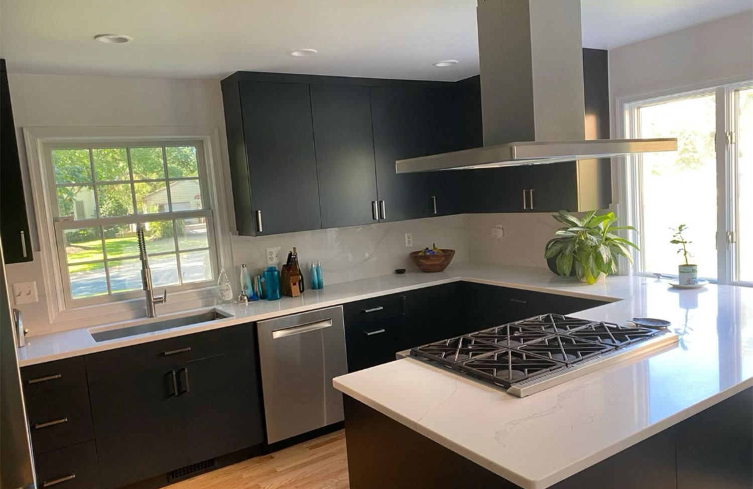 Modern kitchen renovation with vent hood and island cooktop