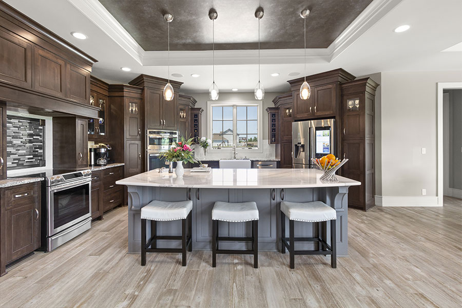 Two-tone kitchen renovation with dark cabinetry and stone island